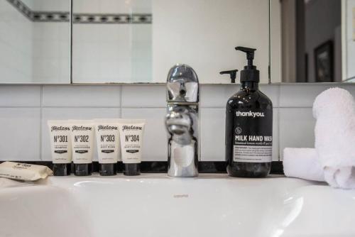 悉尼Great Gatsby Style in the Heart of Double Bay的浴室水槽配有1瓶肥皂和牙膏
