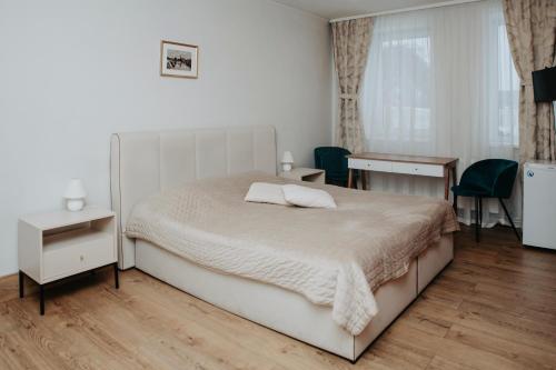 帕内韦日斯Verslo Klasė-easy to stay的卧室配有一张床和一张桌子及椅子
