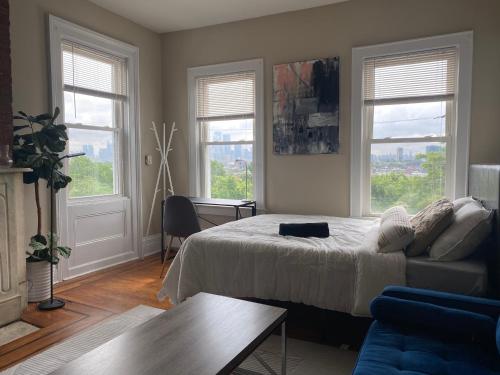 泽西市Cozy apartment with city skyline. Easy commute midtown Manhattan.的一间卧室配有一张床、一张沙发和窗户。