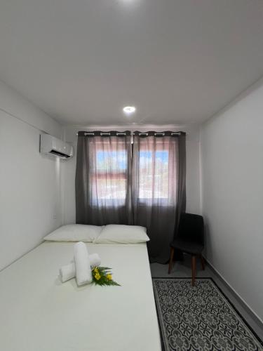 波拉波拉OTEMANU LODGE的卧室配有白色的床,床上有花