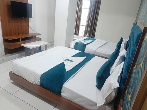 巴罗达ROYAL PRIME HOTEL的酒店客房设有两张床和电视。