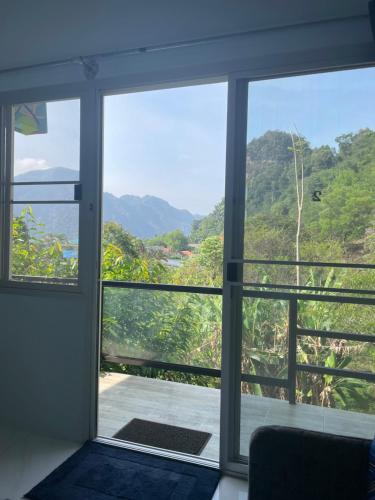 攀牙ลอดจ์พังงา บูทีค的客房设有一个窗户,眺望着群山
