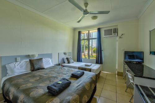 凯瑟琳Riverview Tourist Village的一间卧室配有一张大床和电视