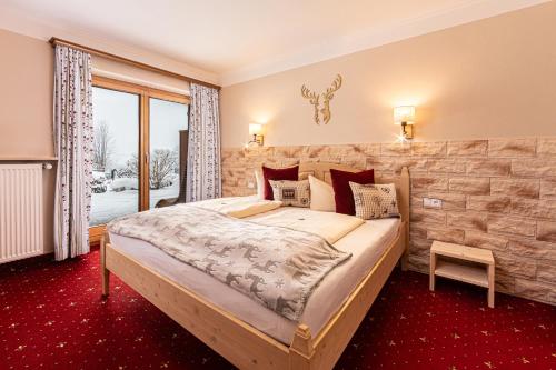 贝希特斯加登阿尔潘伯格扎伯酒店的一间卧室设有一张带石墙的大床
