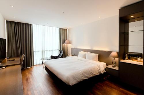 昌原市Sky View Hotel的酒店客房设有一张大床和一张书桌。