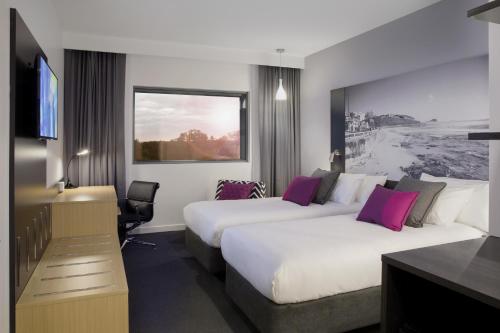 纽卡斯尔纽卡斯尔机场美居酒店的酒店客房配有两张床和一张书桌