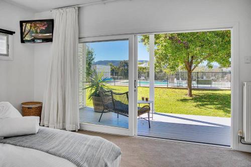 马奇'Bonnie View' A Magnificently Luxurious Retreat的卧室设有滑动玻璃门,可通往庭院。