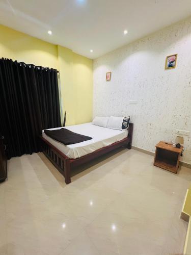 PadinjaratharaLeisure familyvillas的一间卧室配有一张床和一张桌子