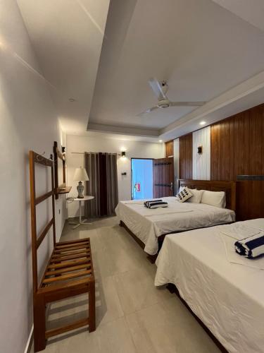 尼拉瓦利NN Beach Resort & SPA的酒店客房设有两张床和窗户。
