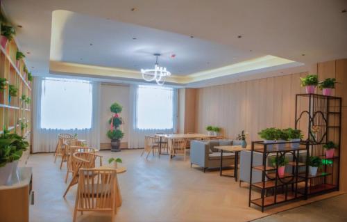 Nanfang尚客优品阿拉尔印象蓝泊湾生态观光园酒店的一间设有桌椅和盆栽的餐厅