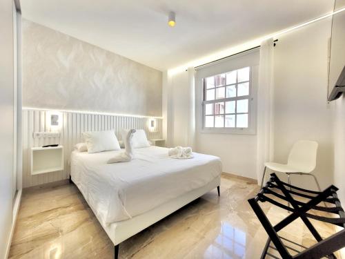 拉克鲁斯The Stylish Apartment的白色卧室配有白色的床和椅子