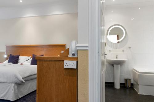 托基巴巴科姆皇家雕工酒店的一间卧室配有床、水槽和镜子