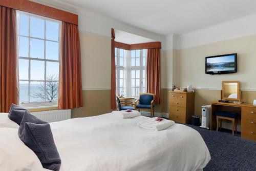 托基巴巴科姆皇家雕工酒店的酒店客房设有一张床、一张书桌和窗户。