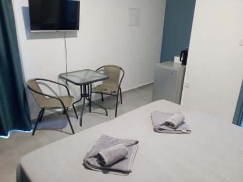 阿依纳帕BlueSuite的一间设有两张床和一张桌子及椅子的房间