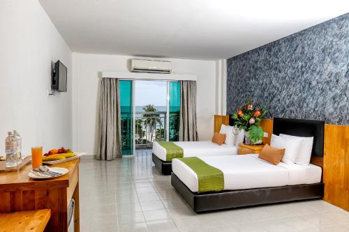 珍南海滩Langkapuri Resort Langkawi的酒店客房设有两张床和一个阳台。
