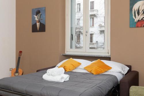 米兰Exclusive apartment Magritte Style的一间卧室配有带毛巾的床