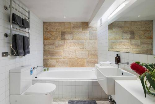 悉尼Elegant Paddington Sandstone Cottage with Parking的带浴缸、卫生间和盥洗盆的浴室