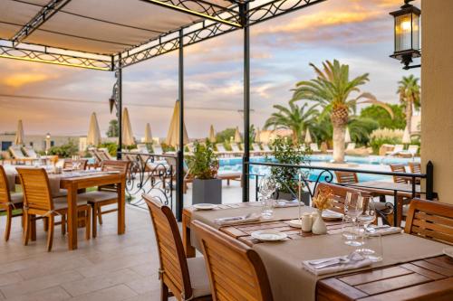 卡尔维Hotel Corsica & Spa Serena的一间带桌椅的海景餐厅