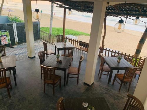 希克杜沃塔马罗海滩度假旅馆的一间带桌椅的餐厅以及海滩