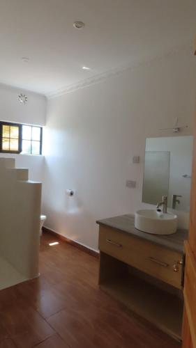 Archers PostSamburu Dik-Dik House & Susuk Self-catering Cottage的一间带水槽和镜子的浴室