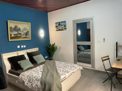 杜阿拉Mado Coliving - Studio Appart, Chambre coin cuisine, Chambre的一间卧室配有一张蓝色墙壁的床