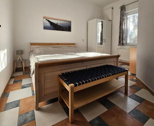 奥斯特西巴德钦诺维茨Ferienwohnung Zinnowitz USE 1501的一间卧室配有一张大床和一张长凳