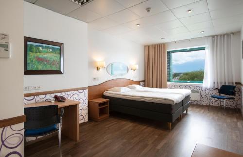 塔林赫斯特苏斯酒店的配有一张床和一张书桌的酒店客房