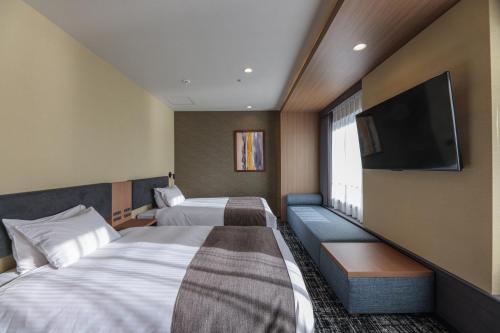 东京东京湾阿祖尔酒店的酒店客房设有两张床和一台平面电视。