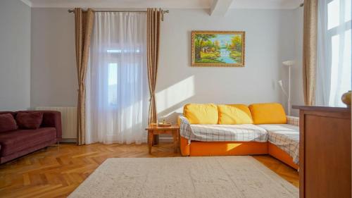 普雷代亚尔Vintage Retreat的客厅配有带黄色枕头的沙发