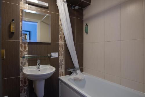 东迪勒姆The Romany Rye Wetherspoon的浴室配有盥洗盆、卫生间和浴缸。