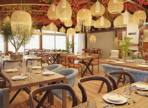 蒂瓦特Luxury Sea Residence by Kristina的餐厅设有木桌、椅子和吊灯。