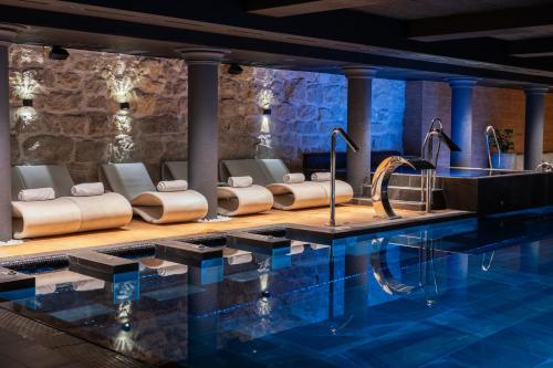 利沃夫Grand Hotel Lviv Casino & Spa的一座带椅子和桌子的酒店游泳池