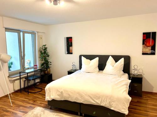 科隆Stylish, cosy flat close to Cologne City Center的卧室配有一张带白色床单和枕头的大床。