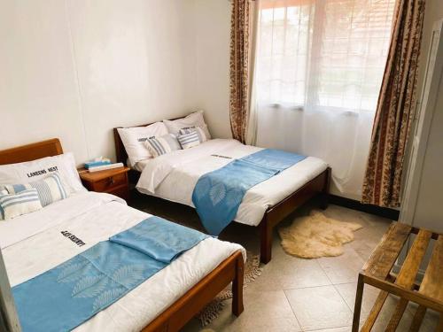 纳库鲁3 Bedroom Laneens Nest的小型客房 - 带2张床和窗户