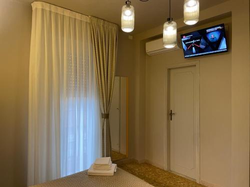 维亚雷焦卢卡斯酒店的一间墙上配有电视的房间和窗户