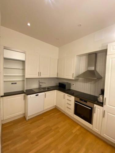 哥德堡Comfortable Home In City Centre的厨房配有白色橱柜和黑色台面