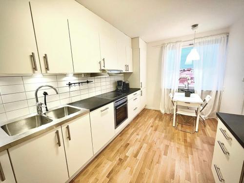 哥德堡Luxurious Apartment With Lovely View的厨房配有白色橱柜、水槽和桌子