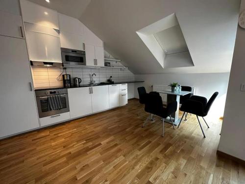 哥德堡Luxury Apartment With Private Terrace的厨房配有白色橱柜和桌椅
