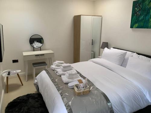 CarshaltonAnnex D. One Bedroom flat in south London的卧室配有带毛巾的大型白色床