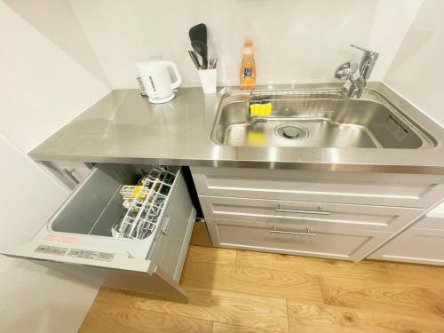 东京山手線恵比寿8分　4人可　的厨房柜台设有水槽和洗碗机。