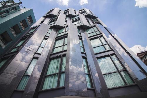 曼谷SureStay Plus by Best Western Sukhumvit 2的一面是一座高大的建筑,边有玻璃窗
