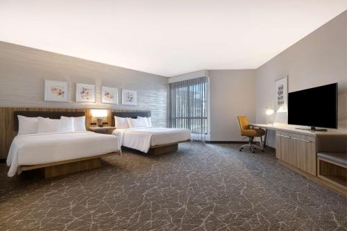 安纳海姆Hilton Garden Inn Anaheim Resort的酒店客房设有两张床和一台平面电视。