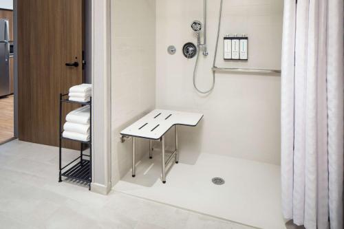 默里迪恩Hyatt Place Boise-Meridian的带淋浴、桌子和毛巾的浴室