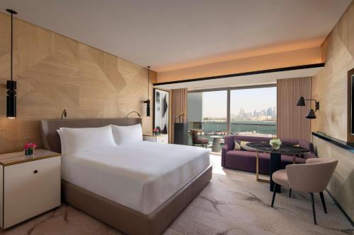 多哈Rixos Gulf Hotel Doha的一间卧室设有一张床和一间客厅。
