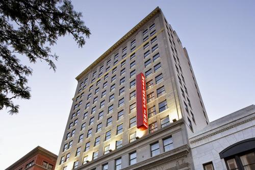 哥伦布哥伦布市区公寓式酒店的一座高大的建筑,上面有红色的标志