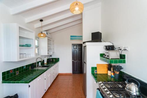CalibishieHodges Bay House的厨房配有白色橱柜和绿色台面