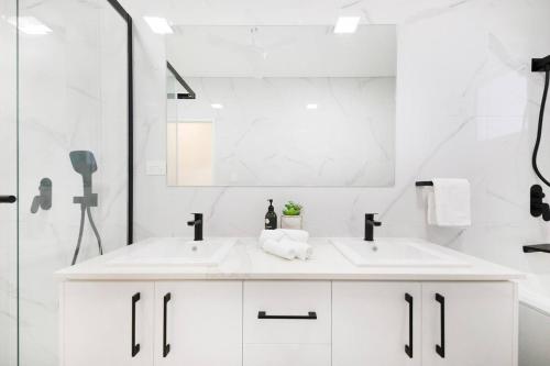 达尔文'Infinity's Edge' Darwin Luxury Waterfront Oasis的白色的浴室设有两个盥洗盆和镜子