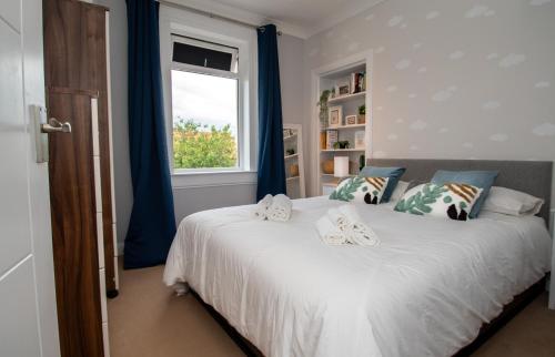 邓弗姆林Linburn Cottage Dunfermline near Edinburgh的一间卧室配有一张带蓝色窗帘的床和一扇窗户