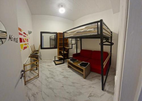 马赛Bed and breakfast chez l'habitant的客房设有双层床和红色沙发。