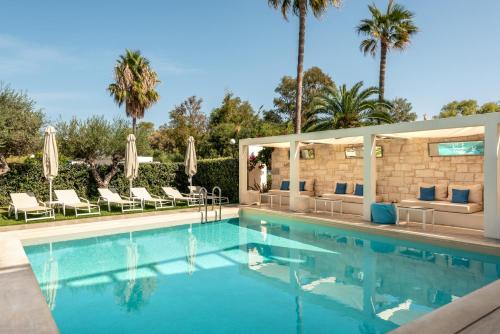 加藤-达拉特索Airis Boutique Hotel & Suites - For adults only的一个带椅子的游泳池,棕榈树